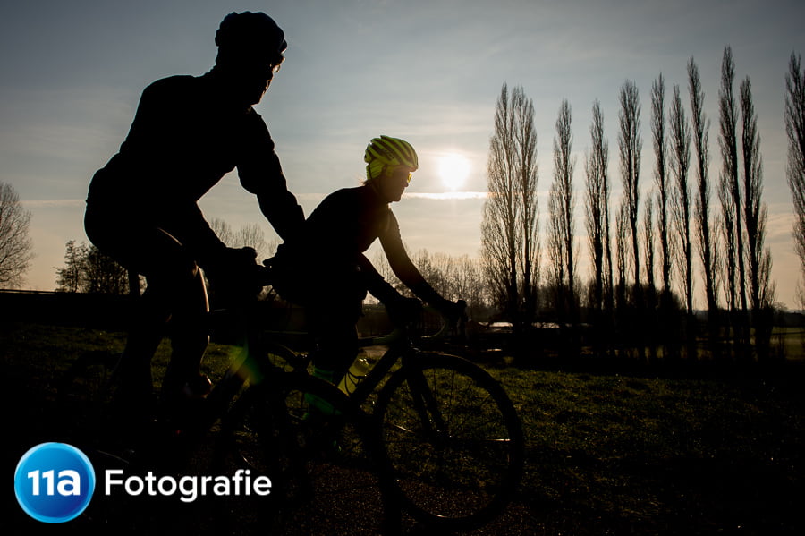 Wielerfoto met een prachtige zonsopkomst en de fietsers in silhouette