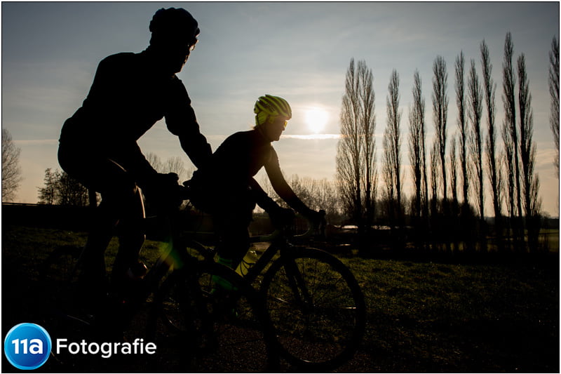 Wielerfoto met een prachtige zonsopkomst en de fietsers in silhouette